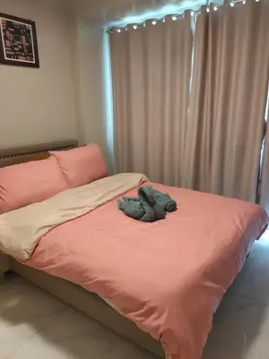 a stuffed animal is laying on a bed at Facing Pool w Balcony MOA BP1741 in Manila