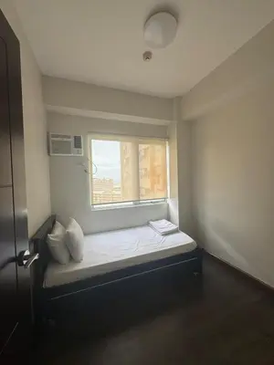 a small room with a bed and a window at East Bay Residences Condo Unit in Muntinlupa in Manila