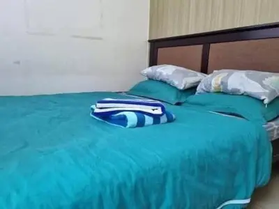 a green bed with blue and white pillows on it at Staycation in Alabang Branch B in Manila