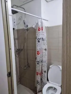 a bathroom with a shower with a toilet and a shower curtain at Staycation in Alabang Branch B in Manila