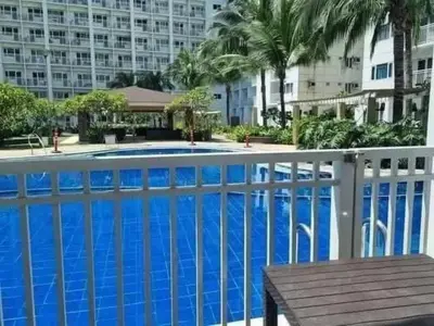a large blue swimming pool with a white fence at Staycation in Alabang Branch B in Manila