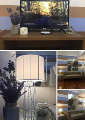 a living room with a television and a table with flowers at Makati City Private Studio across Greenbelt Mall in Manila
