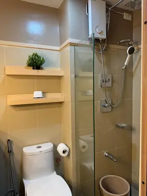 a bathroom with a toilet and a glass shower at Shore 3 Residence Aesthetic 1 BR in Manila