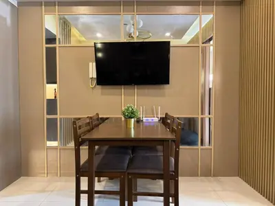 a dining room with a table with chairs and a tv at Shore 3 Residence Aesthetic 1 BR in Manila