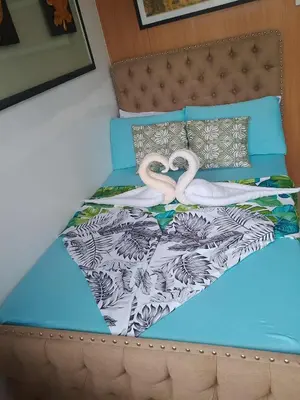 a bed with two pink flamingos on it at 503-1queen bed 1-pull out 1-sofa bed 1- extra matressedsa view in Manila