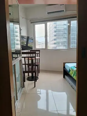 a room with chairs and a table and windows at 503-1queen bed 1-pull out 1-sofa bed 1- extra matressedsa view in Manila