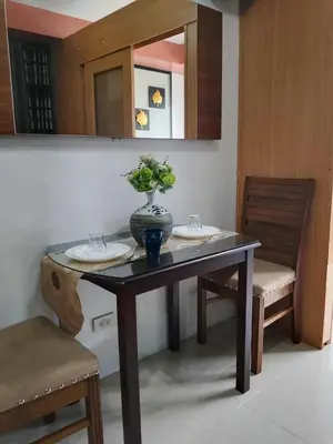 a table with two sinks and a vase with flowers on it at 503-1queen bed 1-pull out 1-sofa bed 1- extra matressedsa view in Manila