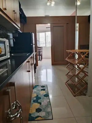 a kitchen with a counter and a tile floor at 503-1queen bed 1-pull out 1-sofa bed 1- extra matressedsa view in Manila