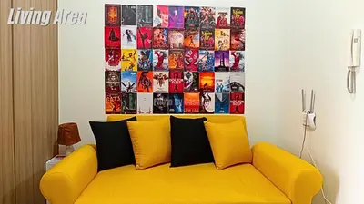 a yellow couch in a living room with a picture on the wall at Casa Via at Shore 2 Residences inside SM MOA Complex, Pasay City in Manila