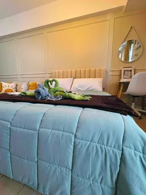 a bed with a bunch of stuffed animals on it at Cozy Unit near Venice Grand Canal Mall McKinley Hill Taguig in Manila