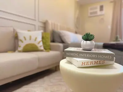 a living room with a couch and a table with books at Cozy Unit near Venice Grand Canal Mall McKinley Hill Taguig in Manila