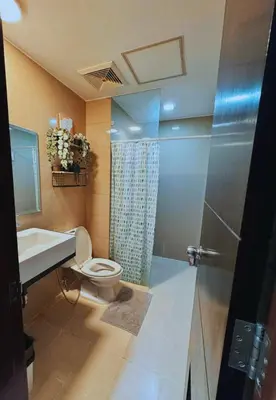 a bathroom with a toilet and a sink and a shower at Cozy Unit near Venice Grand Canal Mall McKinley Hill Taguig in Manila