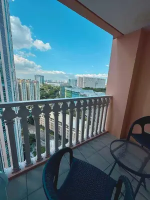 a balcony with a table and chairs and a view of the city at Cozy Unit near Venice Grand Canal Mall McKinley Hill Taguig in Manila