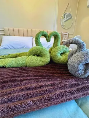a bed with two swans shaped like hearts at Cozy Unit near Venice Grand Canal Mall McKinley Hill Taguig in Manila