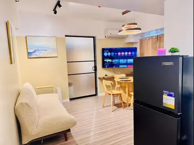 a living room with a refrigerator and a table at Cozy Vibes Retreat in Makati in Manila