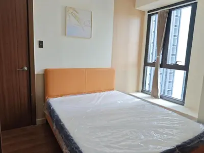 a bed in a room with a large window at 1BR near Podium or Marco Polo in Manila
