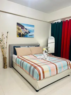 a bedroom with a bed with colorful curtains at One Tree villas - Hyuna Place, Across NAIA T3 in Manila