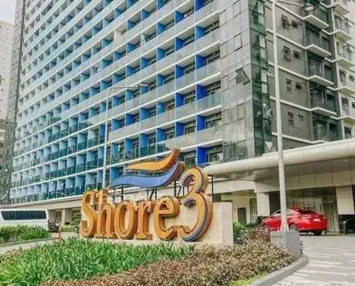 a sign in front of a large building at Mao condotel shore 3 residence in Manila