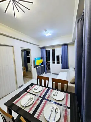 a dining room with a table and chairs and a living room at Suntrus,t Solana Condominium - Ermita, Manila - SM Manila in Manila