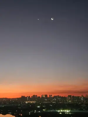 a view of a city at sunset with the moon at Suntrus,t Solana Condominium - Ermita, Manila - SM Manila in Manila