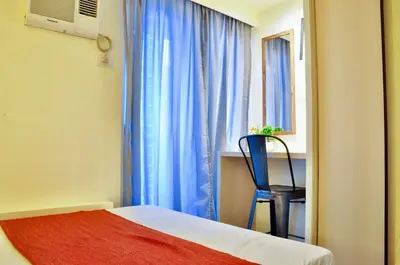 a bedroom with a bed and a chair and a window at Modern Zen 1-bedroom with balcony in Manila