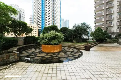 a fountain in a park in a city with buildings at Modern Zen 1-bedroom with balcony in Manila