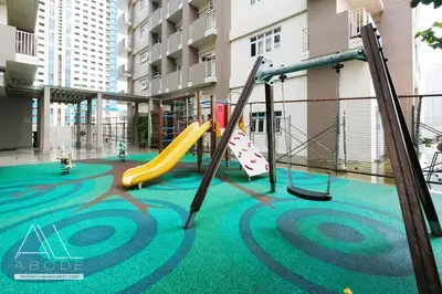 a playground in a building with a slide and swings at Modern Zen 1-bedroom with balcony in Manila