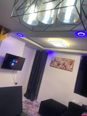 a living room with a tv and purple lights at Condo apartment in Manila