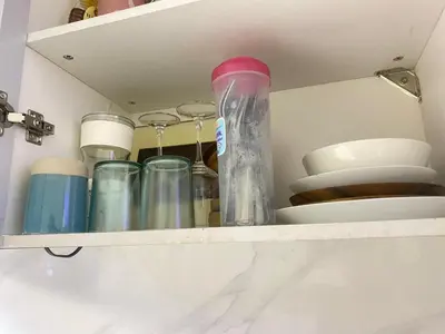 a shelf with a bunch of cups and plates at Condo apartment in Manila