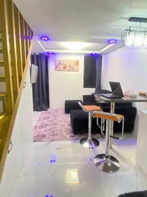 a living room with a table and chairs and a couch at Condo apartment in Manila
