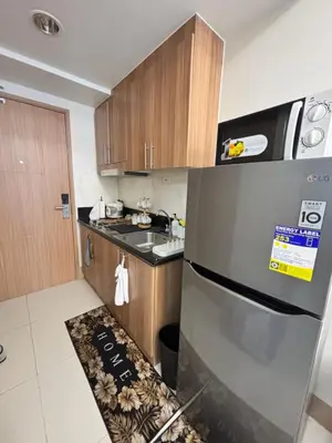 a kitchen with a stainless steel refrigerator and a sink at Meteoria Staycation in Manila