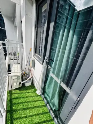 a balcony with green grass next to a window at Meteoria Staycation in Manila