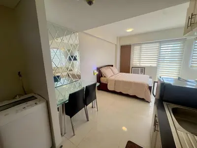 a bedroom with a bed and a kitchen with a sink at Elegant Suite with Balcony l Free wifi and netflix I Across NAIA T3 Airport in Manila
