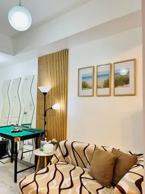 a living room with a couch and a ping pong table at Azure Beach View with Balcony PS4 Billiards in Manila