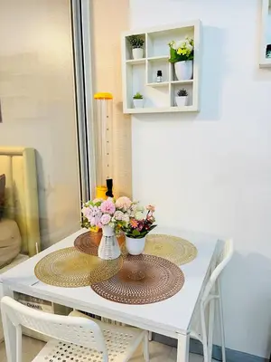 a white table with two vases of flowers on it at Azure Beach View with Balcony PS4 Billiards in Manila