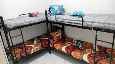 three bunk beds in a room with shoes on them at BahayMandaragat2 in Manila
