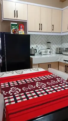 a kitchen with a red and white blanket on a table at BahayMandaragat2 in Manila