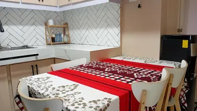 a kitchen with a table with a red and white table cloth at BahayMandaragat2 in Manila