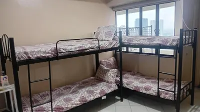 two bunk beds in a room with a window at BahayMandaragat2 in Manila
