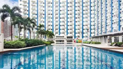 a swimming pool in front of a large building at Bernie and Adel's Property Rental in Manila
