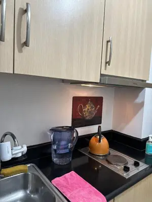 a kitchen counter with a sink and a stove at Bernie and Adel's Property Rental in Manila