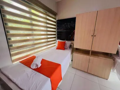 a bedroom with two beds and a large window at OYO 1158 Kegama Residences 2 in Cavite