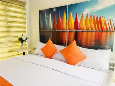 a bedroom with a bed with orange and orange pillows at OYO 1158 Kegama Residences 2 in Cavite