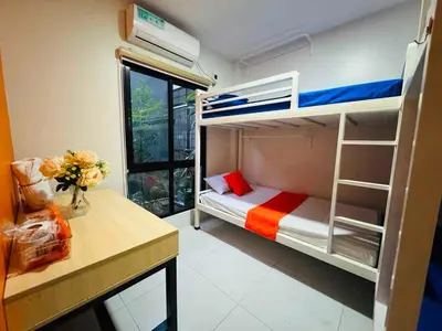 a bedroom with a bunk bed and a desk with flowers at OYO 1158 Kegama Residences 2 in Cavite