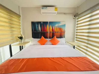 a bedroom with a large bed with orange pillows at OYO 1158 Kegama Residences 2 in Cavite