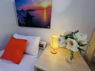 a vase of flowers on a table with a lamp at OYO 1158 Kegama Residences 2 in Cavite