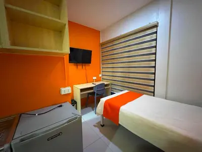 a small room with a bed and a desk with a television at OYO 1157 Kegama Residences 1 in Cavite