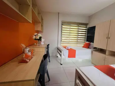 a kitchen with a bedroom with a bed and a table at OYO 1157 Kegama Residences 1 in Cavite