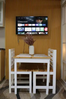 a white table and chairs with a tv on a wall at Venice Grand Canal View Condo in Manila