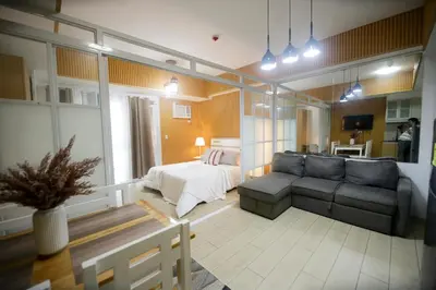 a living room with a couch and a bed at Venice Grand Canal View Condo in Manila